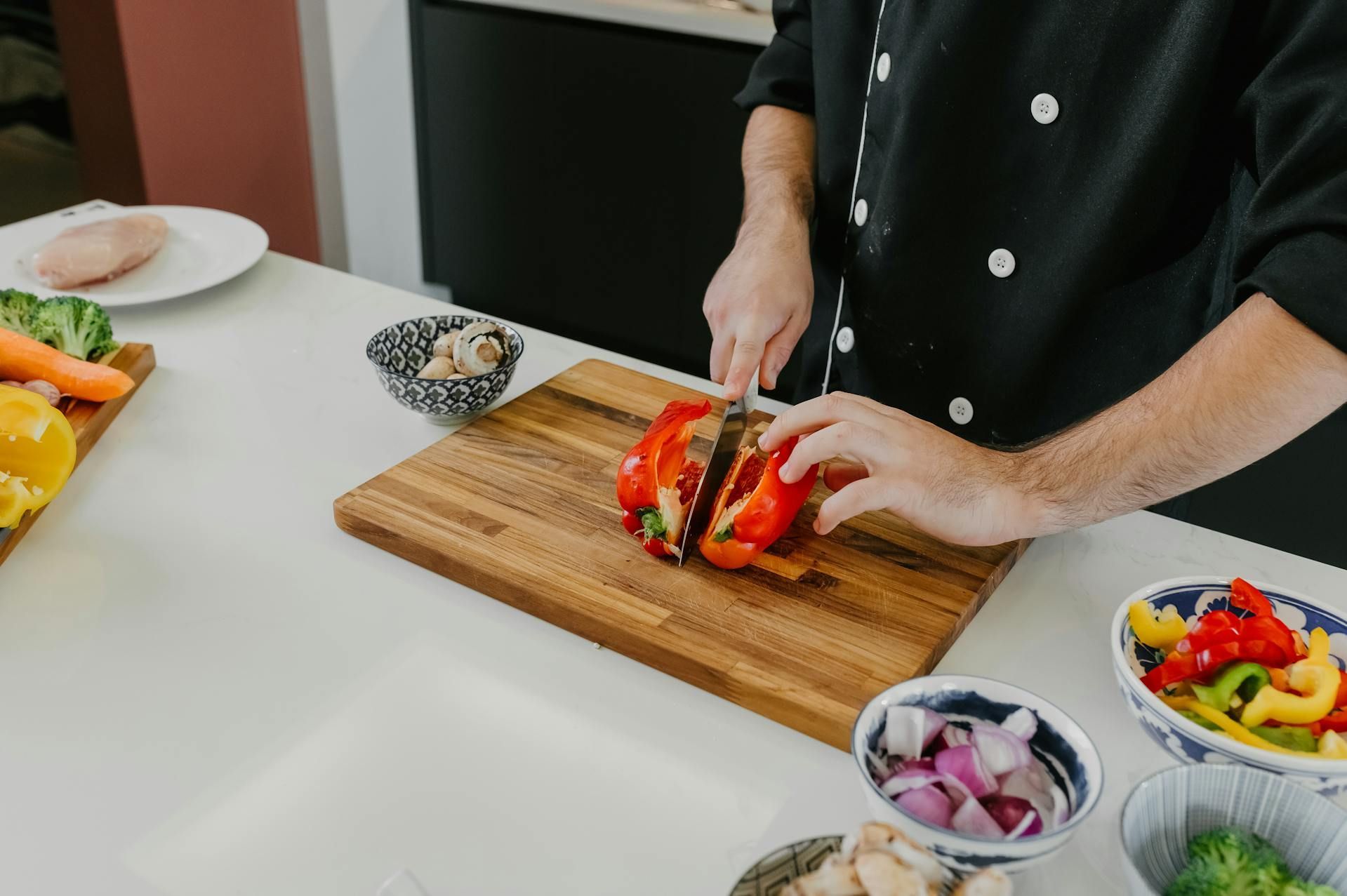Cook chopping a pepper in a kitchen