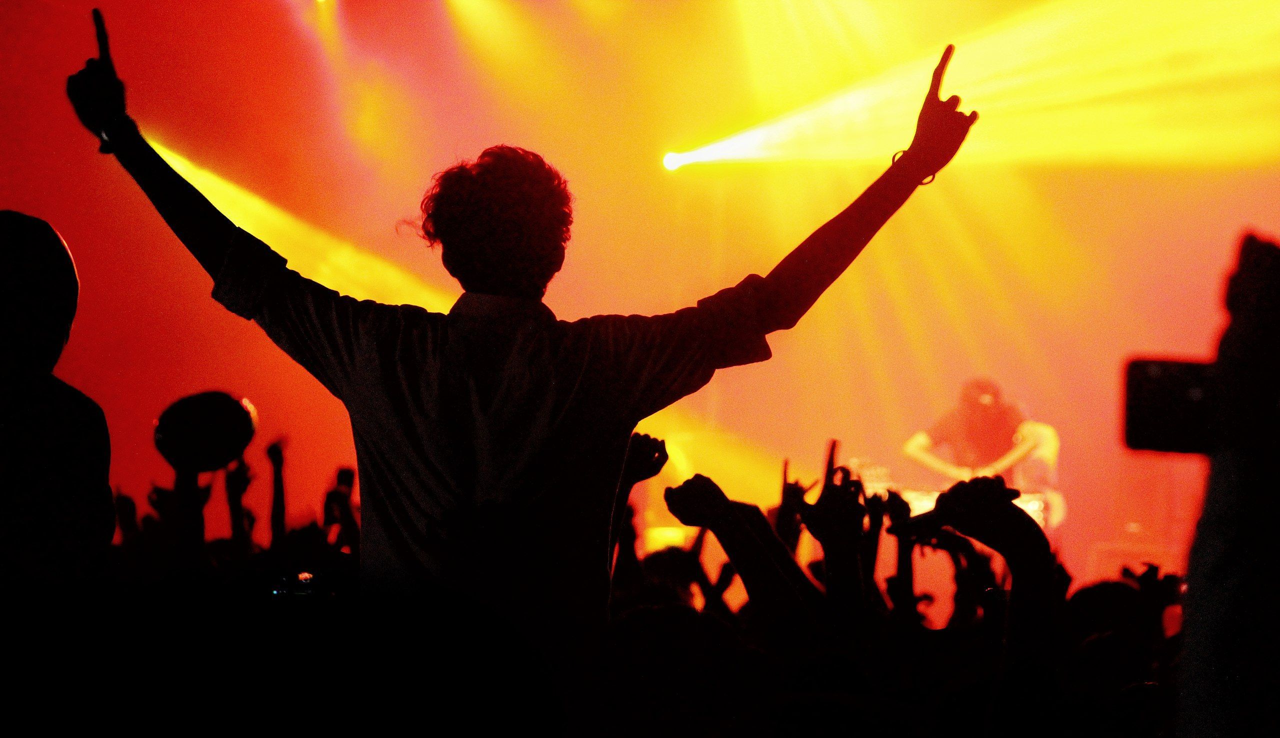 Man silhouetted against the light at a concert